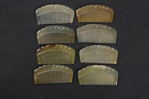 Detailed view of eight semi-circular natural ox horn combs with unique carved patterns