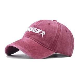 Detailed close-up of burgundy washed cotton baseball cap with white Forever embroidery