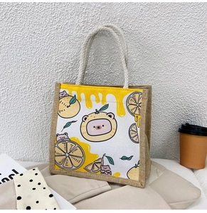 Detail of linen tote bag featuring a cute cartoon bear print and woven cotton rope handle