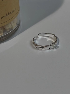 Macro shot of silver S925 ring featuring lava texture and a translucent moonstone bead