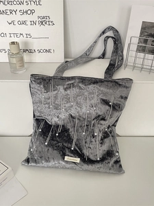 Grey velvet pleated tote bag with pearl accents and minimalist metal brand tag detail