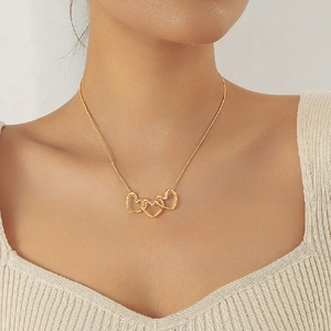 Minimalist gold heart pendant necklace for women worn by a model in a studio setting