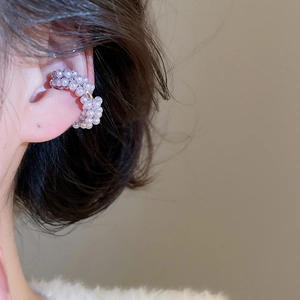 Detail of elegant double-layered pearl ear cuff with gold accents worn by a model