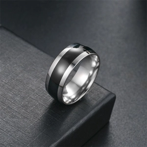 Macro view of polished titanium steel ring featuring a sleek black enamel oil drip inlay
