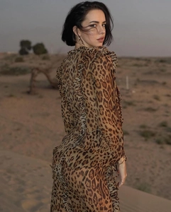 Detail of ruffle accents and leopard print on a lightweight chiffon long sleeve dress