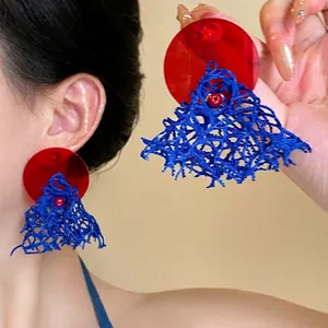 Detailed shot of retro flower bead earrings with blue weave and red acrylic pendant