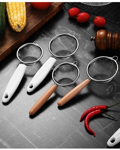 Detail of stainless steel fine mesh strainers with natural wooden handles on a kitchen counter