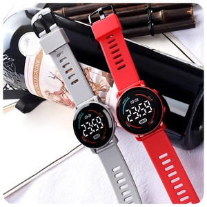 Close-up of dual round LED sports watches showing grey and red silicone straps