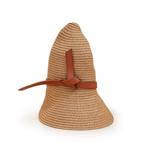 Zoom détaillé sur la texture de paille tressée et le ruban à nœud en cuir du chapeau de soleil