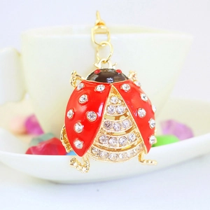 Sparkling crystal beetle keychain in gold metal with red enamel wings and clear rhinestones