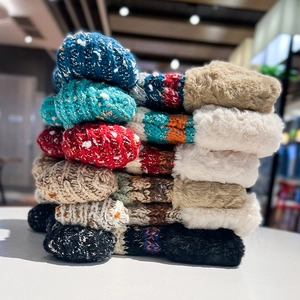 Detailed stack of colorful knit winter beanies featuring warm faux fur plush lining