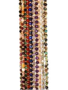 Close-up of colorful faceted natural stones and gold bead necklace in bohemian style