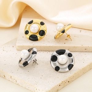 Detail of French style gold and silver earrings with pearl inlay and black polka dots
