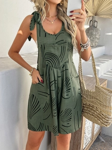 Detail of green bohemian jumpsuit featuring black line print and pocket design on cotton fabric