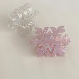 Elegant snowflake hair claws in white and pearlescent pink with subtle diamond accents