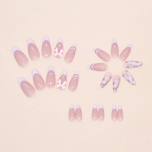 Close-up of pink French almond press-on nails with 3D bows and glitter marble patterns
