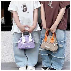 Detail of mini kids handbags with Tochaso letter patch and zippered front pockets