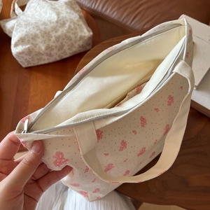Detailansicht der Innenseite einer geblümten Canvas-Tasche mit Reißverschlussfach