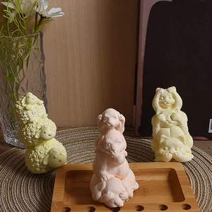 Detail showing stacked sheep, dog, and cat animal shaped candles in various warm colors