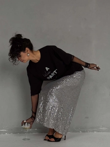Camiseta negra con estampado para mujer combinada con falda larga de lentejuelas plateadas