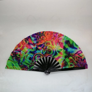 Detail of 33cm folding fan showing colorful psychedelic tie-dye pattern on black bamboo frame