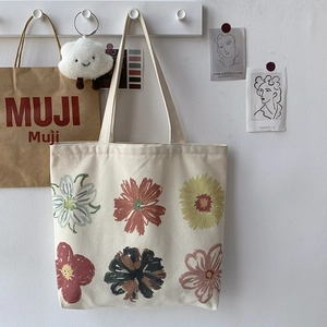 Close-up of floral canvas tote bag featuring botanical prints and natural cotton texture