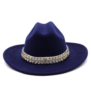Macro detail of dark blue wool fedora hat with white studded pearl decorative band