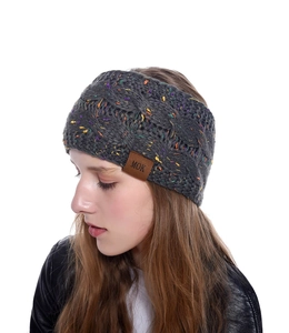 Gros plan d'un bandeau en maille gris foncé avec mouchetures colorées et écusson MOK.