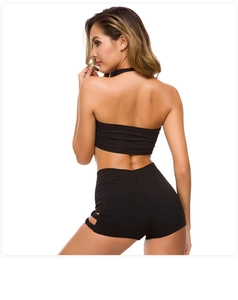 Vista posteriore di pantaloncini yoga neri a vita alta e crop top con sexy spacchi laterali