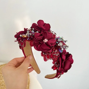 Macro detail of wine red headband featuring 3D floral embroidery and sparkling rhinestones
