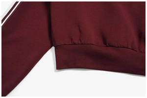 Detail of burgundy outdoor hoodie showing ribbed hem and white side stripes