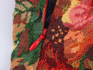 Detail of red invisible zipper and textured jacquard fabric on a French retro dress