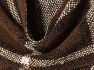 Close-up of premium brown plaid knit fabric texture on a vintage French style coat