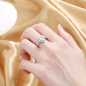 Close-up of heart-cut cubic zirconia ring with halo stones on gold silk background