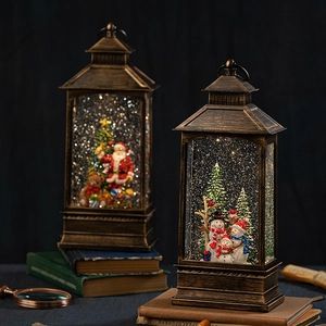 Vintage Christmas lantern snow globe with Santa and snowman on antique books decor