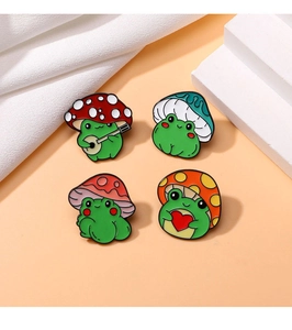 Detailed view of four cute enamel frog pins with mushroom hats and red heart motifs