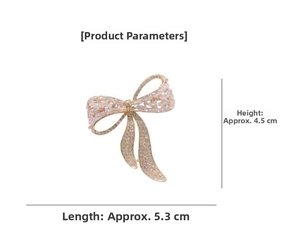 Macro detail of a crystal-encrusted bow brooch in gold finish with 5.3cm x 4.5cm dimensions