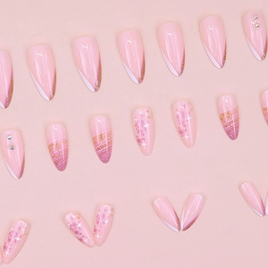 Pink almond stiletto press-on nails with gradient, gold glitter, and star patterns