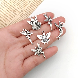 Antique silver angel and fairy charms for DIY necklaces shown in hand for size