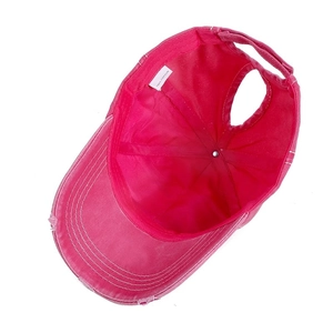 Detail of rose pink ponytail cotton cap showing velcro strap and 100% cotton label