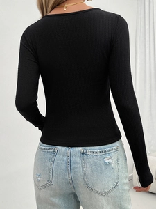 Detail of a slim-fit black Y2K ribbed long sleeve top showing the textured fabric back