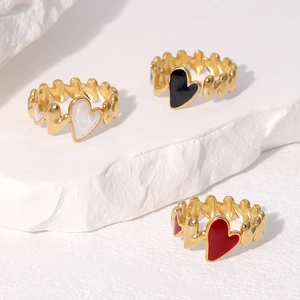Three heart-shaped rings in white black and red enamel with a polished golden finish