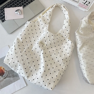 Detail einer weißen Canvas-Tasche mit Herzprint und Sorakka-Label auf einem Schreibtisch