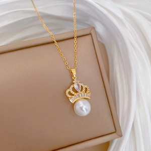 Macro detail of gold crown necklace with teardrop stone, sparkling zircons and pearl