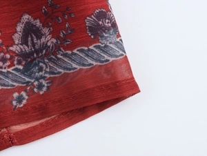 Detailed view of chiffon fabric with dark floral print and precise stitching on the hem