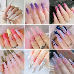 Détail de faux ongles cercueil longs avec dégradés pailletés et motifs strass 3D