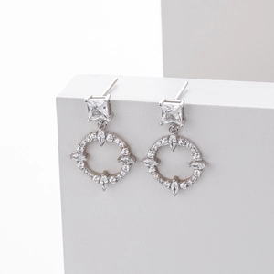 Detail of silver S925 earrings featuring square studs and geometric round zircon pendants