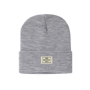 Close-up of grey knit beanie with Brooklyn Twenty letter patch and ribbed texture