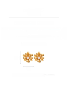 Close-up of 18k gold-plated flower earrings featuring a white faux pearl center