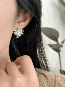 Close-up of 18k gold-plated pearl stud earrings worn by a model in French vintage style